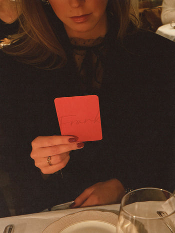 FRANK HET KAARTSPEL vrouw in tafelsetting met spelkaart in haar hand